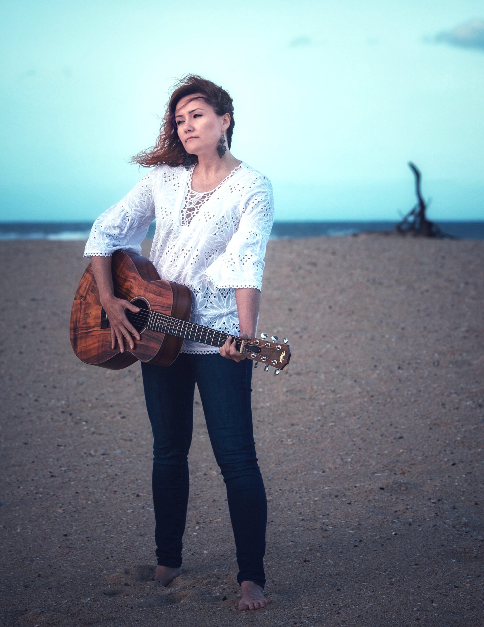 Innessa at the beach with guitar